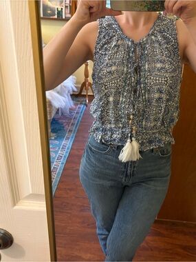 Sleeveless tie neck peplum ruffle hem top with tassels and buttons